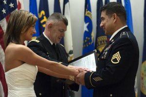 Staff Sgt. Phillip Vitela, right and his wife, Kate, receive a blessing from Maj. Billy Graham, chaplain, after exchanging wedding vows Jan. 29 at French Theater on Lewis Main.